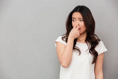 woman pinching nose to block out bad smell
